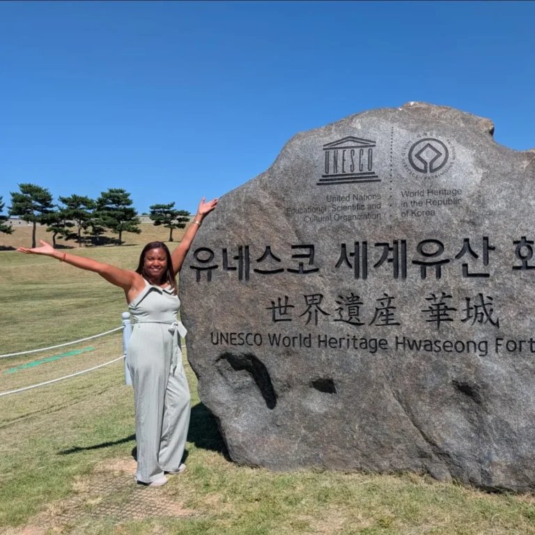Viajera junto a la piedra de Patrimonio de la Humanidad de la Fortaleza de Hwaseong, Corea del Sur