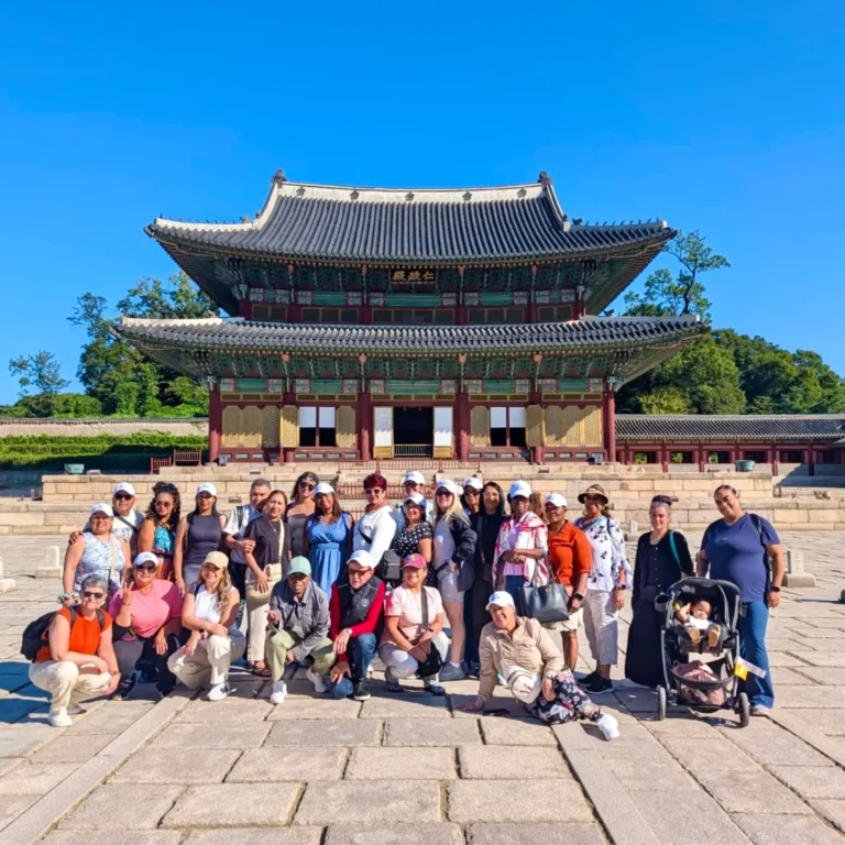 Grupo de viajeros frente a un palacio tradicional coreano